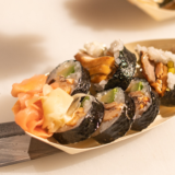 sushi futomaki na brązowym talerzyku