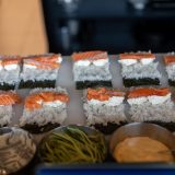 ładnie zaprezentowane sushi na desce z sosami